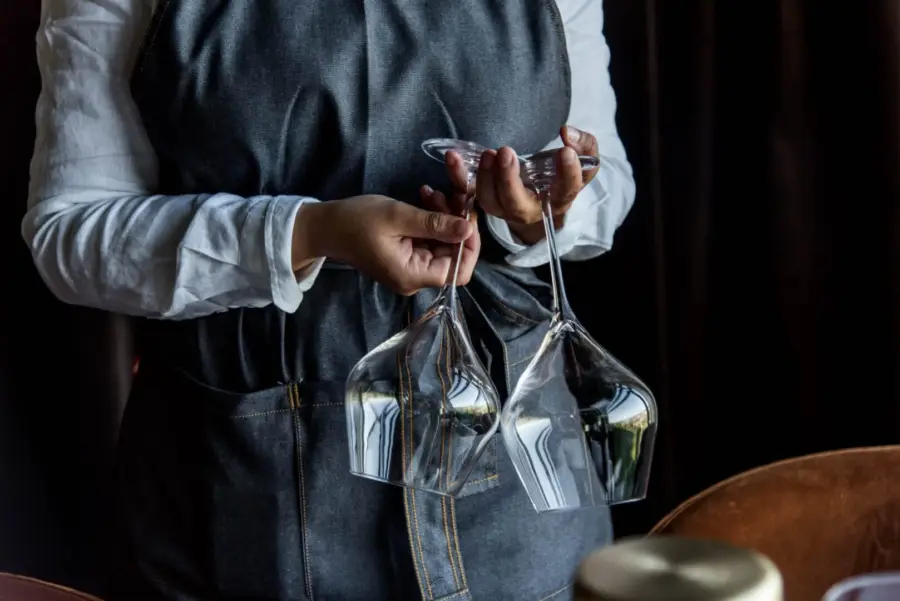 servitris håller två vinglas