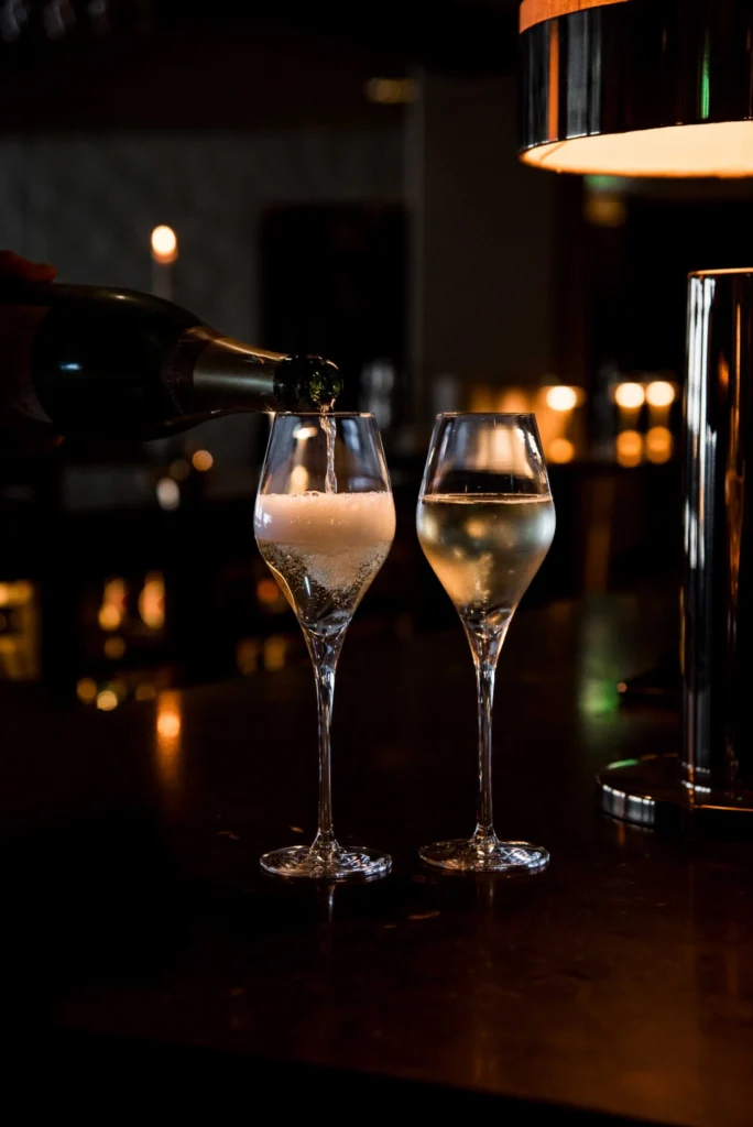 häller upp mousserande vin i glas